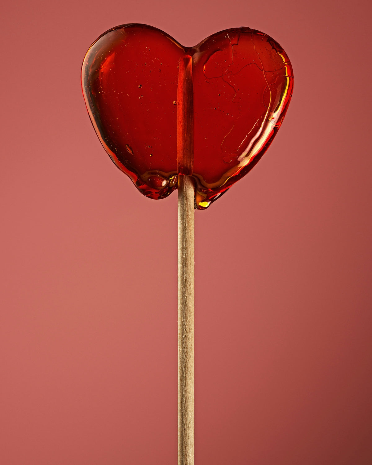 A heart shaped lollipop on a stick