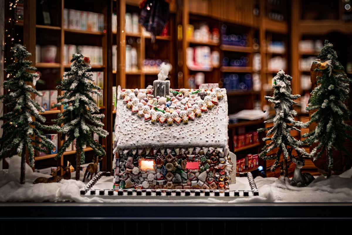 Gingerbread house decorated with candy and surrounded by trees