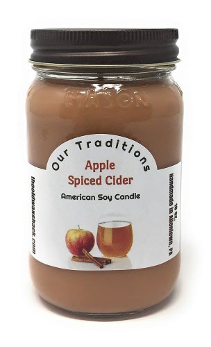 A 16 oz. mason jar soy candle with a label reading 'Apple Spiced Cider' and depicting an image of an apple and cinnamon sticks.