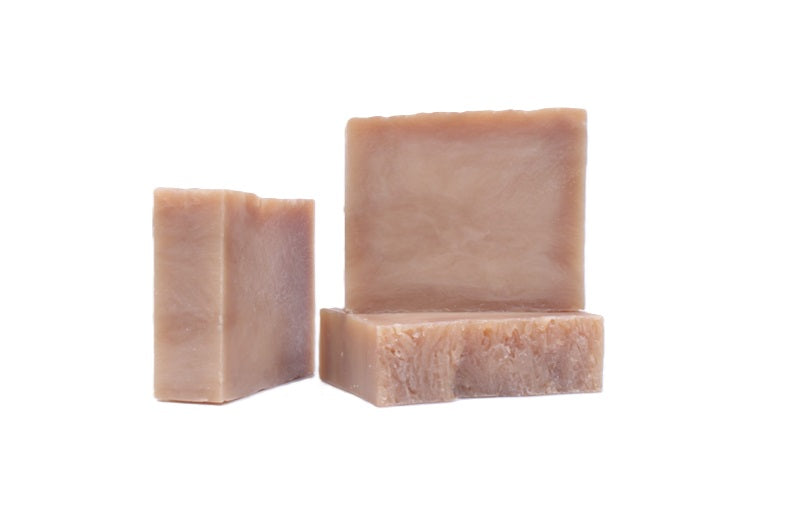 Three bars of brown sugar fig goats milk soap on a white background