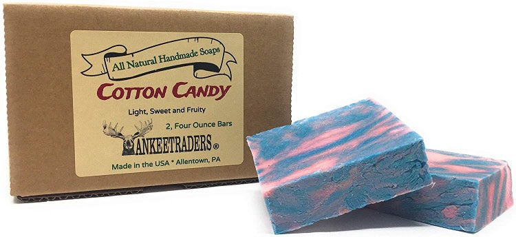 A packaged handmade soap labeled 'COTTON CANDY' with a description of being light, sweet, and fruity. The soap is shown in two pieces with a vibrant pink and blue color pattern.
