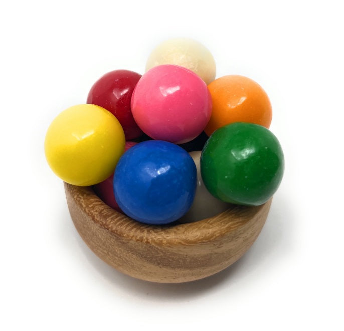 A set of eight glossy, colorful dubble bubble gumballs yellow, red, pink, orange, green, blue, and cream, arranged in a small wooden bowl on a white background.