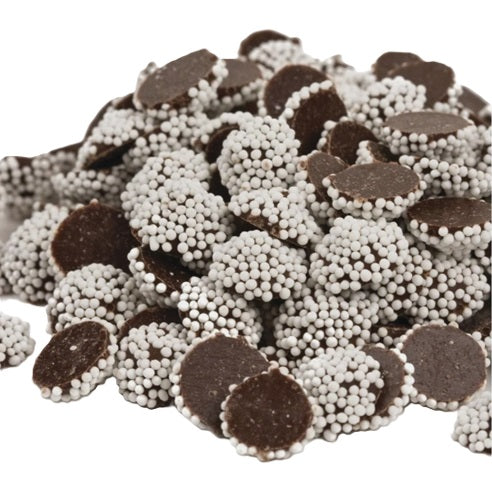 Dark chocolate nonpareils with white sprinkles on a white background