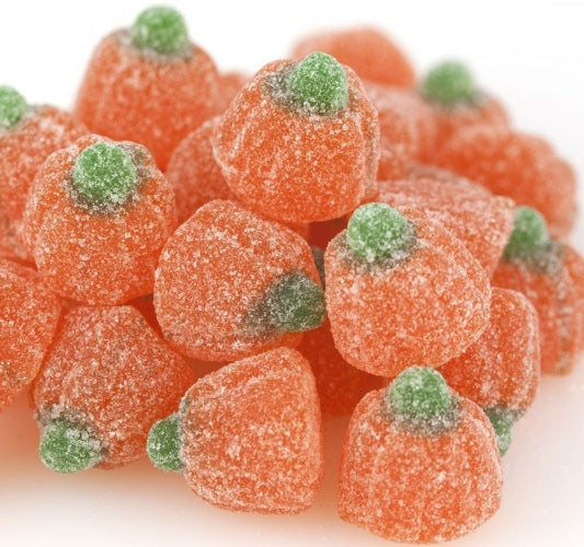A pile of orange sugar frosted jelly pumpkin candies shaped like pumpkins with green stems.