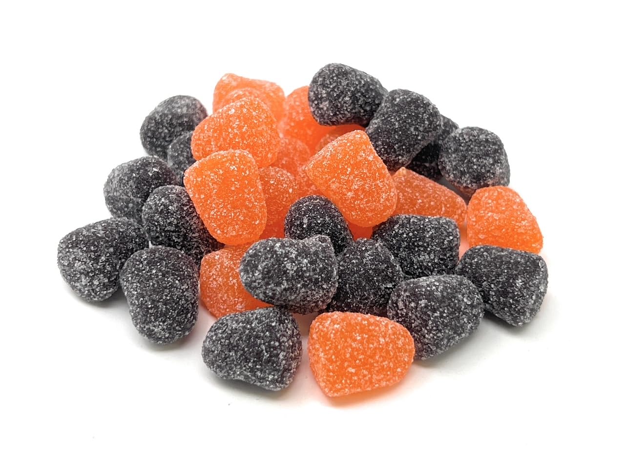 Orange and black licorice spice drops candies on a white background