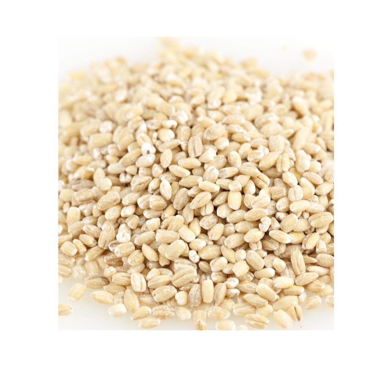 A pile of uncooked, pearled hulled barley grains on a plain white background.